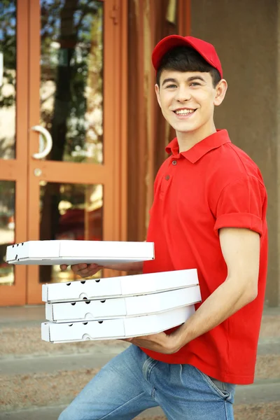 Man delivering pizza box near house — Stock Photo, Image