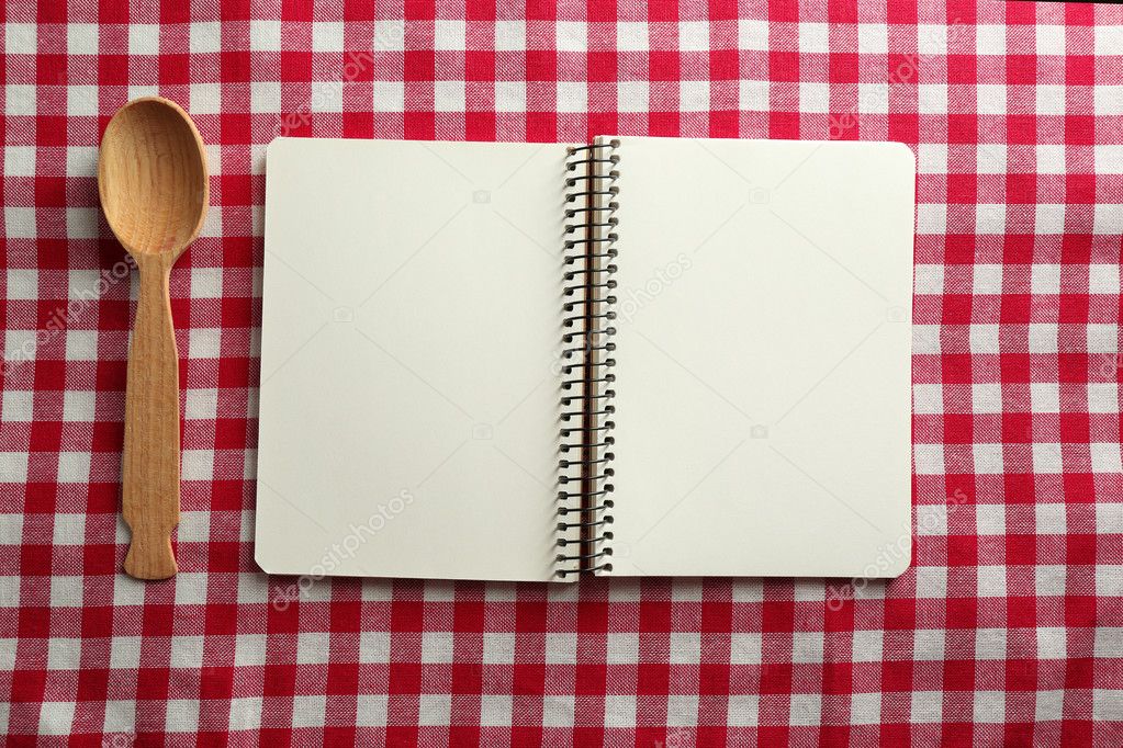 Open recipe book on color tablecloth background