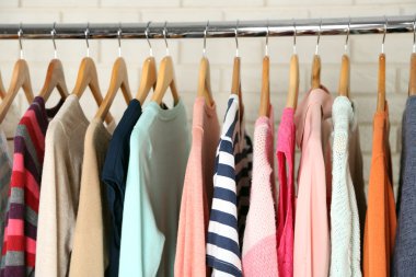 Askılarda farklı giysiler. Kapatın.