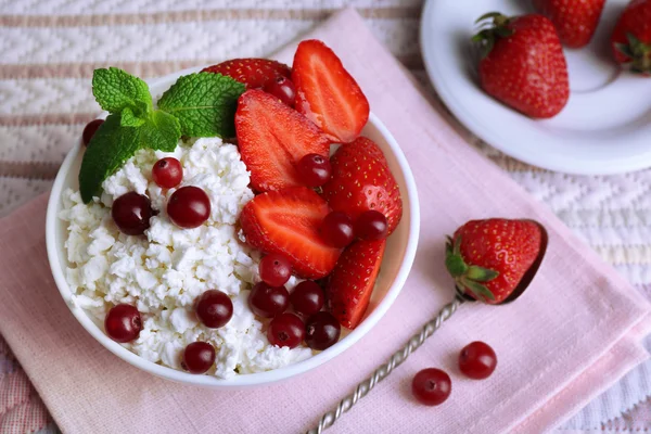 Bowl of cottage cheese with strawberry and cranberry on table, closeup — Stock Photo, Image