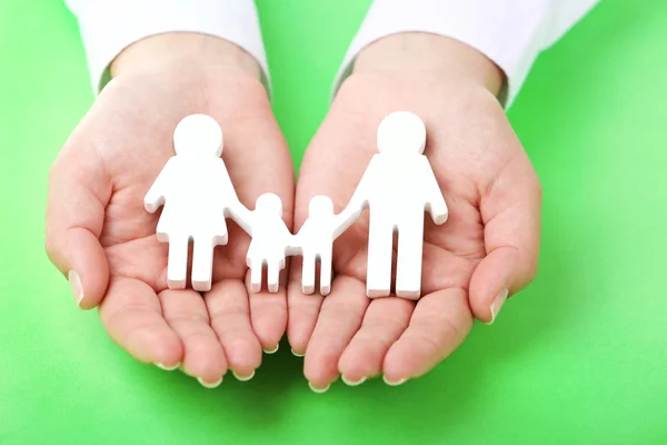 Female hands holding toy family — Stock Photo, Image