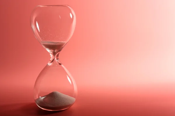 Hourglass on pink background — Stock Photo, Image