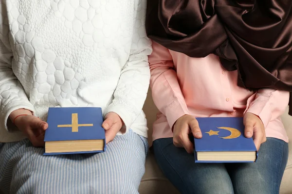 Dois amigos segurando livros com símbolos religiosos — Fotografia de Stock