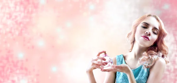 Belle femme avec bouteille de parfum en fleurs sur fond rose — Photo