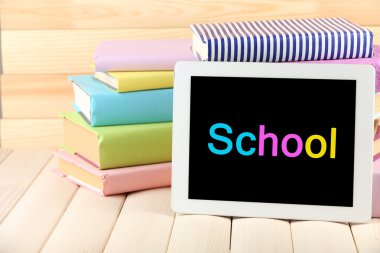 PC tablet ve ahşap masa, ahşap arka plan üzerinde kitap