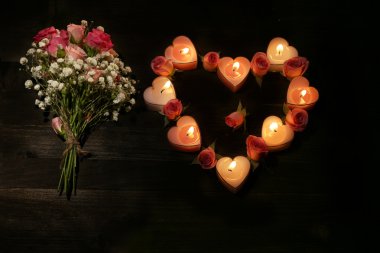 Romantik atmosferi ile mum ışık ve koyu arka plan üzerinde çiçekler