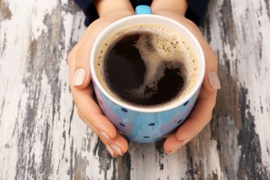 kahve ahşap arka plan üzerinde tutan eller