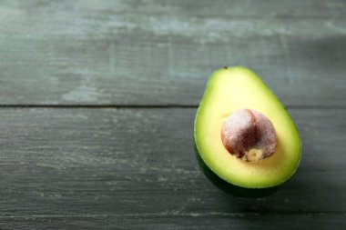 Ahşap arka planda dilimlenmiş avokado.