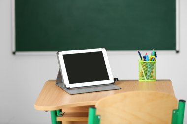 İleti örneği ve yazı tahtası arka plan üzerinde sınıfta tablet ile ahşap masa
