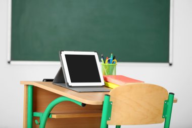 İleti örneği ve yazı tahtası arka plan üzerinde sınıfta tablet ile ahşap masa