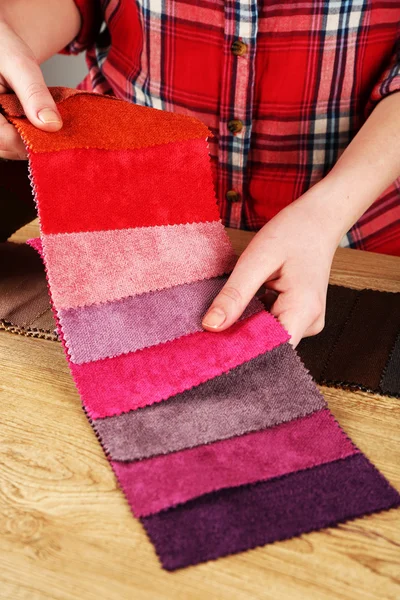 Woman chooses scraps of colored tissue on table close up — Stock Photo, Image