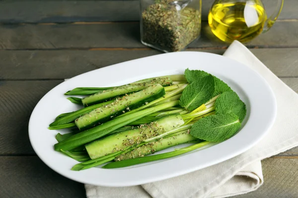 Ensalada verde con pepino y puerro salvaje sobre mesa de madera, primer plano —  Fotos de Stock