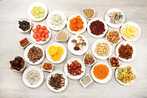 Different products on saucers on wooden table, top view — Stock Photo, Image