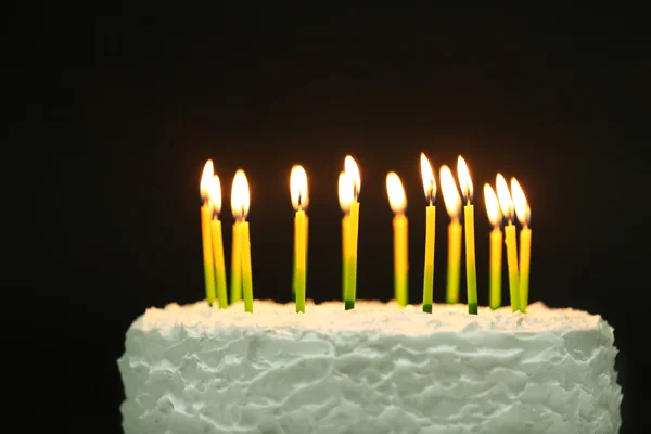 Bolo de aniversário com velas no fundo escuro — Fotografia de Stock