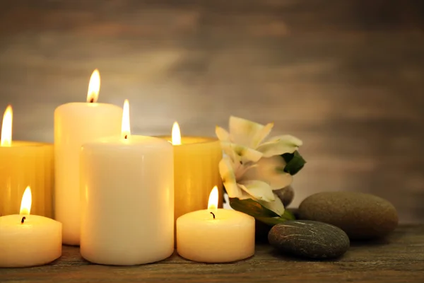 Hermosa composición con velas y piedras de spa sobre fondo de madera —  Fotos de Stock