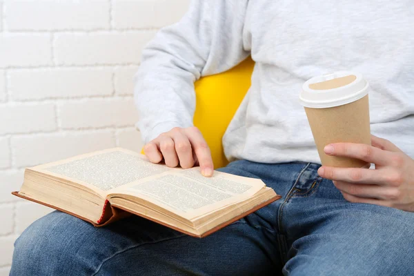 Young man reading book, close-up, on light background — Stock Photo, Image