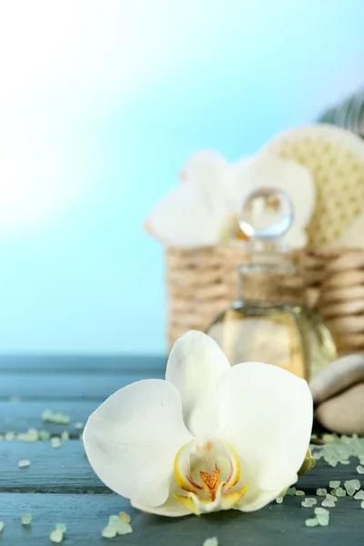 Still life with beautiful blooming orchid flower, spa treatment on wooden table, on bright background — Stock Photo, Image