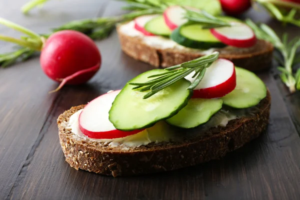 Délicieux sandwichs aux légumes et légumes verts sur table en bois — Photo