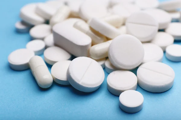 Pile of pills on color table, closeup — Stock Photo, Image