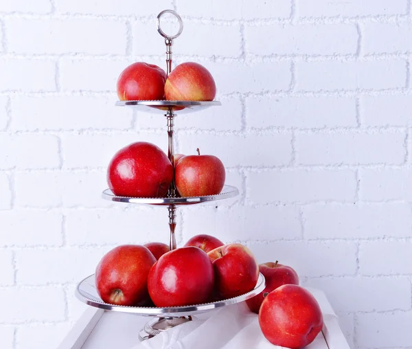 Pommes mûres savoureuses sur plateau de service sur fond de mur de briques — Photo