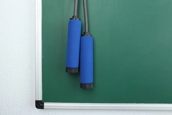 Skipping rope on green blackboard background — Stock Photo, Image