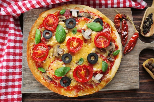 Sabrosa pizza con verduras y albahaca en la mesa de cerca —  Fotos de Stock