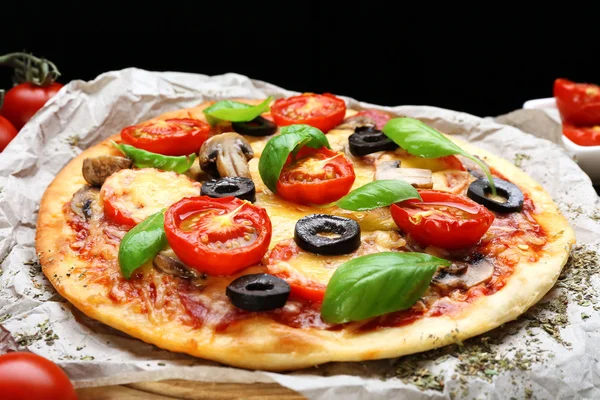 Leckere Pizza mit Gemüse und Basilikum auf dem Tisch aus nächster Nähe — Stockfoto
