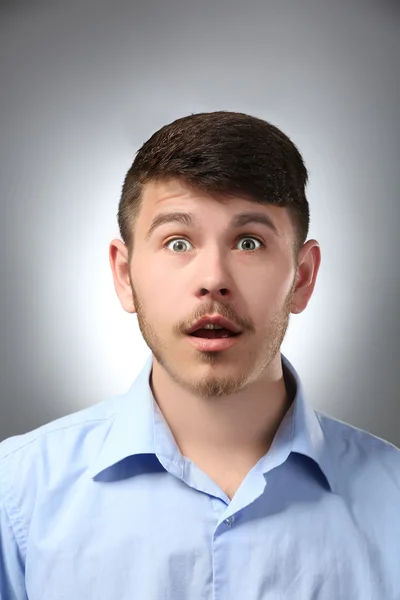 Retrato del hombre sorprendido sobre fondo gris —  Fotos de Stock