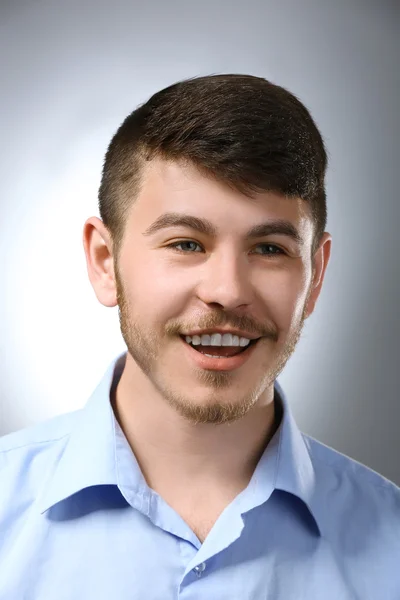 Retrato de homem sorridente em fundo cinza — Fotografia de Stock