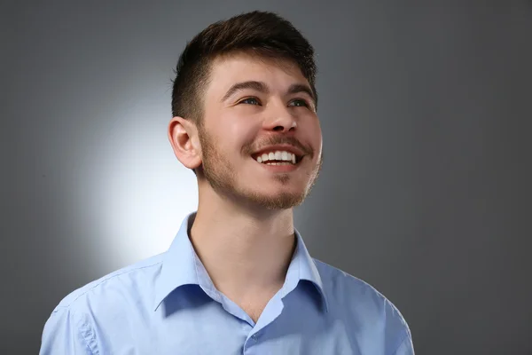 Portrait of smiling man on gray background — Stock Photo, Image