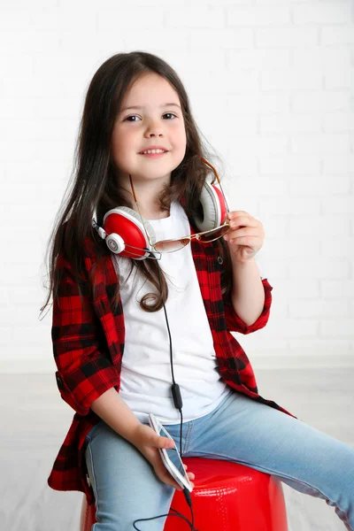Menina bonita com fones de ouvido no quarto — Fotografia de Stock