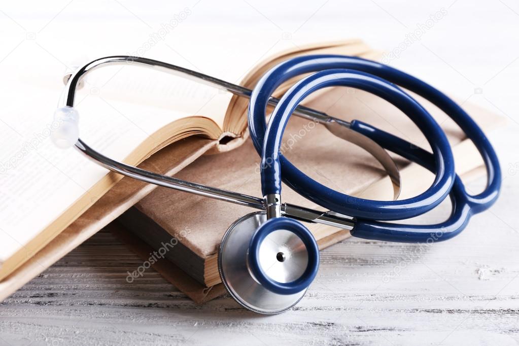 Stethoscope on book on wooden table
