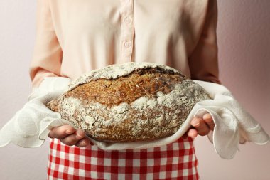 Woman holding tasty fresh bread, close up clipart