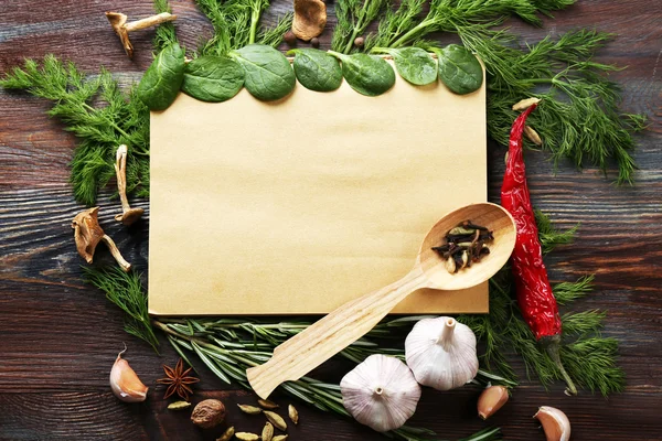 Open recipe book with fresh herbs and spices on wooden background — Stock Photo, Image