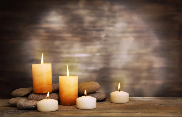 Hermosa composición con velas y piedras de spa sobre fondo de madera —  Fotos de Stock