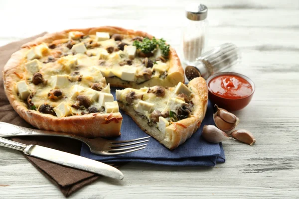 Cheese pie with mushrooms, herbs and sour creme, on napkin, on wooden table background — Stock Photo, Image