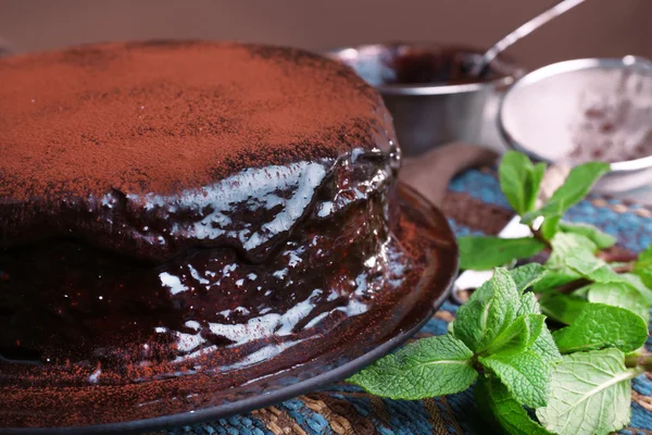 Delicious chocolate cake with icing in plate on table, closeup — Stock Photo, Image