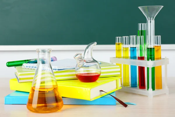 Biurko w klasie chemii z probówki na zielona tablica tło — Zdjęcie stockowe