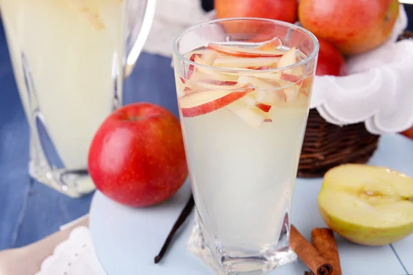 Glass and carafe of apple cider with fruits and spices on table close up — Stock Photo, Image