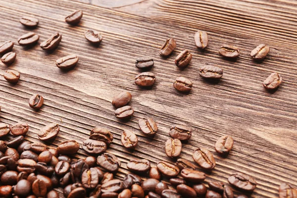 Granos de café sobre fondo de madera — Foto de Stock