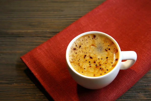 Xícara de café em guardanapo na mesa de perto — Fotografia de Stock