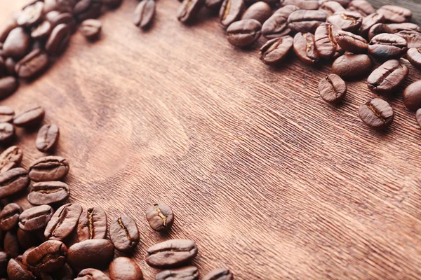 Grãos de café em fundo de madeira — Fotografia de Stock