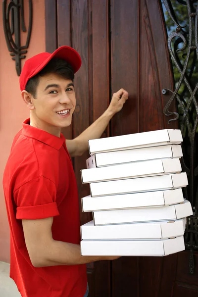 年轻男子送比萨盒附近的房子 — 图库照片