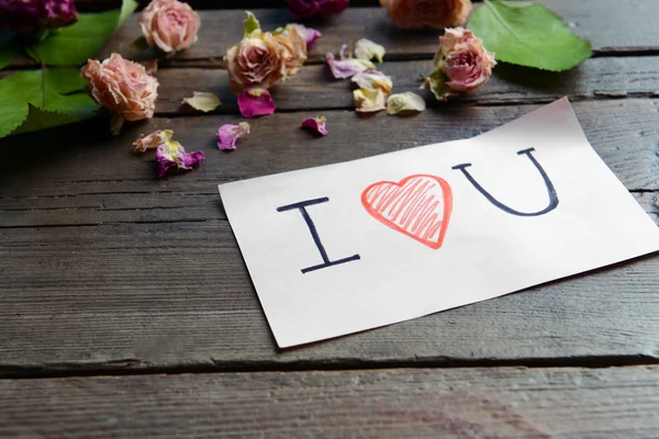 Written message with dry flowers on wooden table close up — Stock Photo, Image