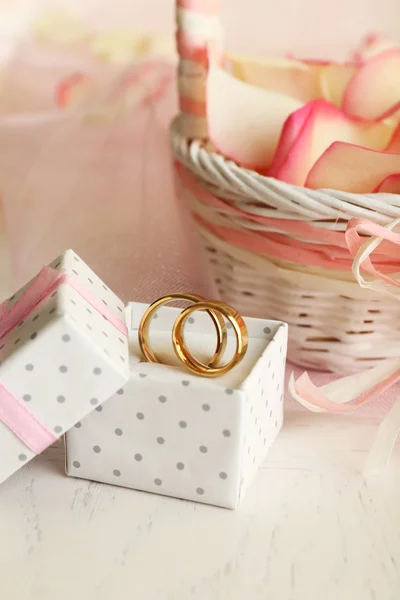 Hochzeitskorb mit Rosenblättern auf dem Tisch, auf hellem Hintergrund — Stockfoto