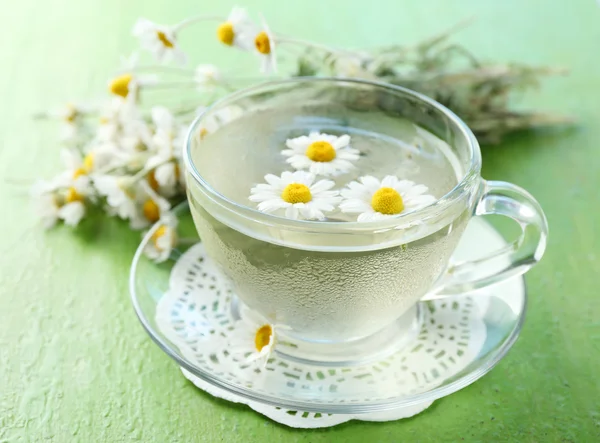 Cup of chamomile tea with chamomile flowers and tasty muffins — Zdjęcie stockowe