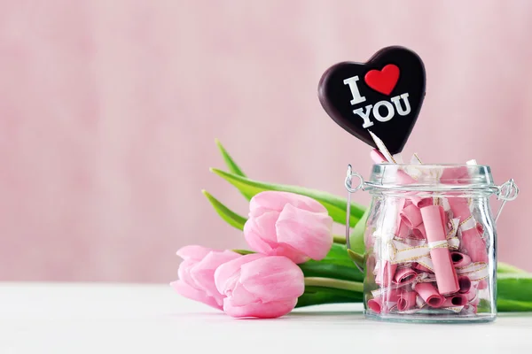 Beautiful pink tulips with jar of papers — Stockfoto