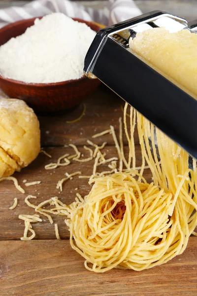 Hacer vermicelli con máquina de pasta sobre fondo de madera —  Fotos de Stock