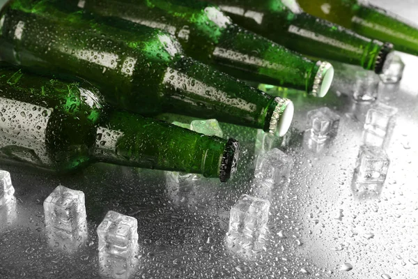 Cam şişe bira ıslak tablo arka plan üzerinde buz küpleri ile — Stok fotoğraf
