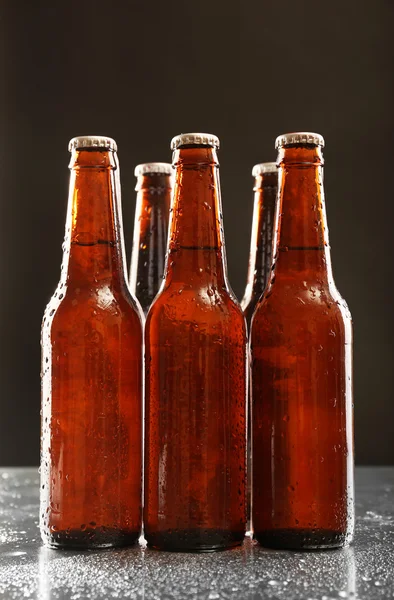 अंधेरे पृष्ठभूमि पर बीयर की ग्लास बोतलें — स्टॉक फ़ोटो, इमेज